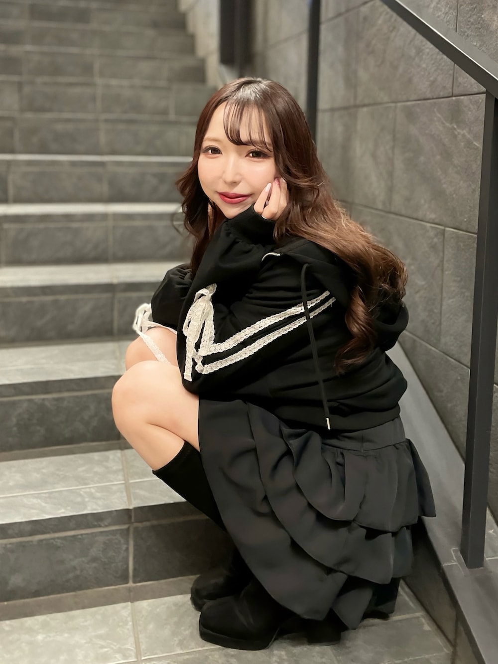 ブラック系のパーカー、ブラック系のキャミソール、ブラック系のスカートを着用したレディースの春コーディネートの2枚目の写真