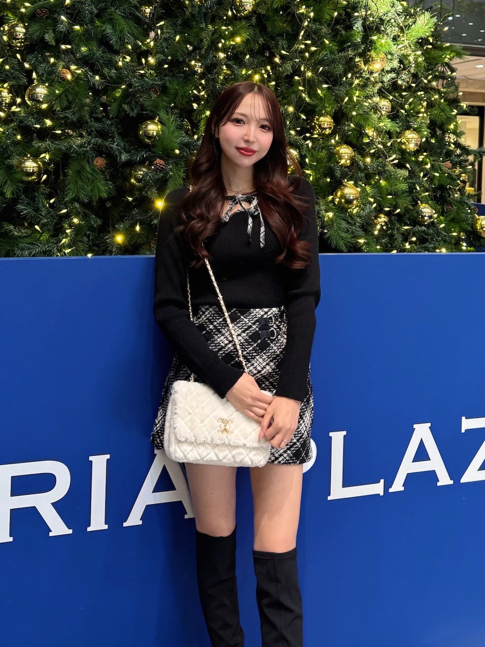 ブラック系のニット/セーター、ブラック系のスカート、ホワイト系のショルダーバッグを着用したレディースの冬コーディネートの4枚目の写真