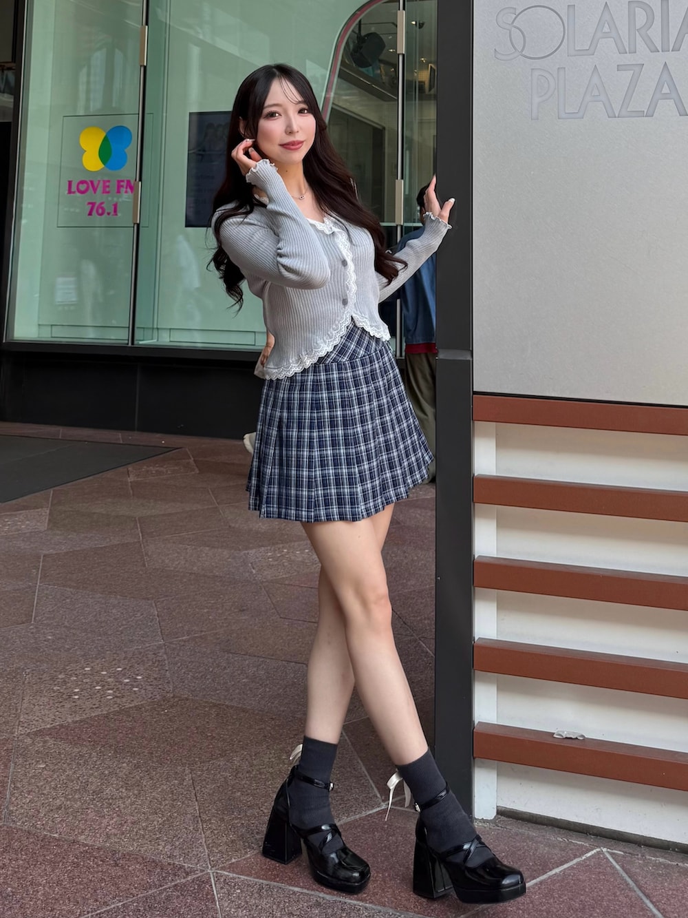 グレー系のニット/セーター、ブルー系のスカートを着用したレディースの秋コーディネートの2枚目の写真