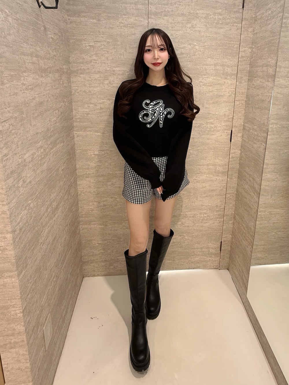 ブラック系のその他パンツ、ブラック系のニット/セーター、ブラック系のブーツを着用したレディースの春コーディネートの2枚目の写真