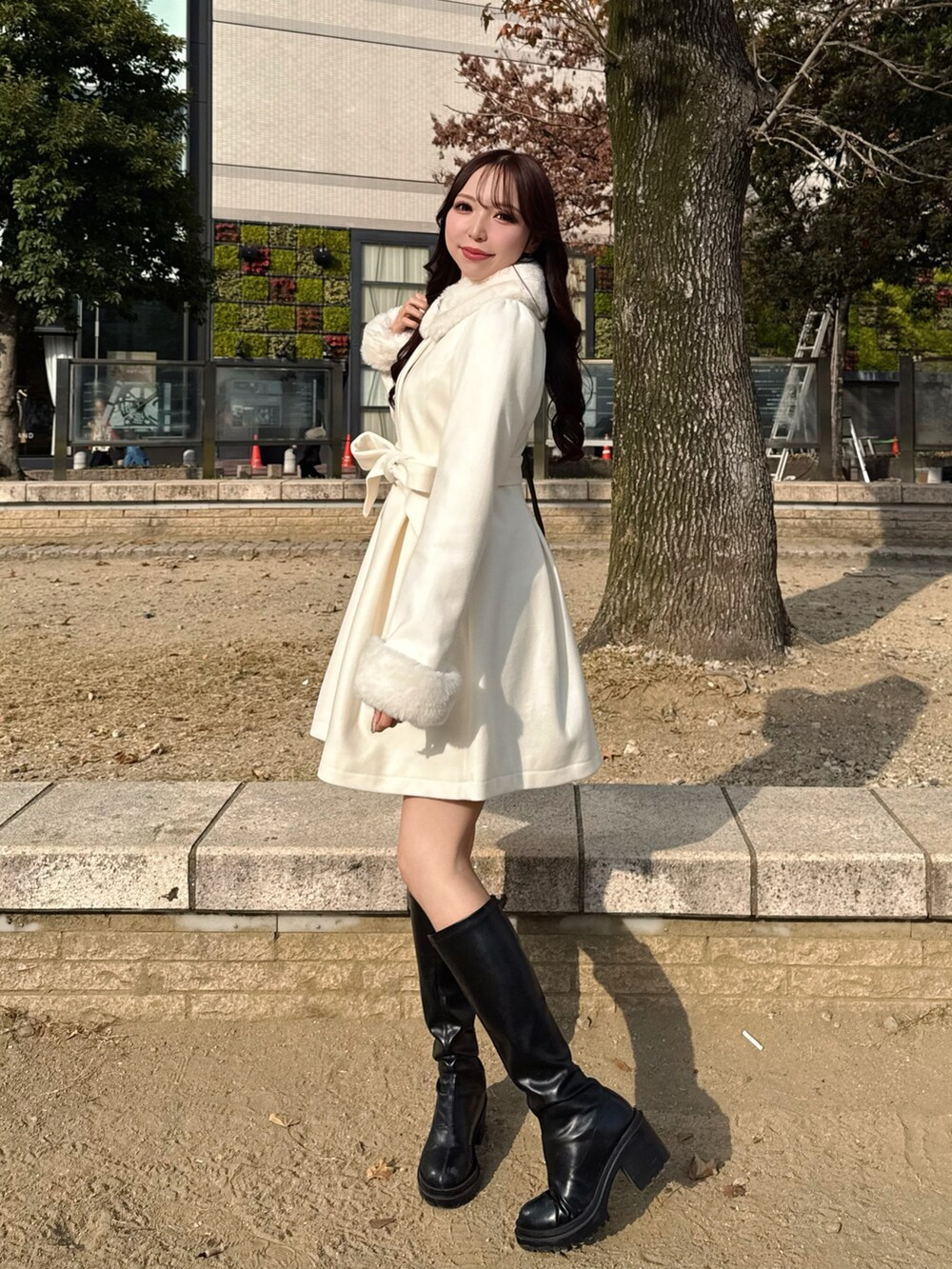 ブラック系のハンドバッグ、ホワイト系のその他アウターを着用したレディースの冬コーディネートの3枚目の写真