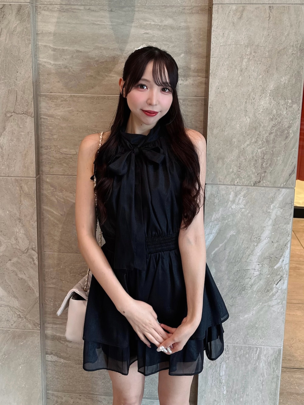 ブラック系のワンピース、ホワイト系のショルダーバッグを着用したレディースの夏コーディネートの6枚目の写真