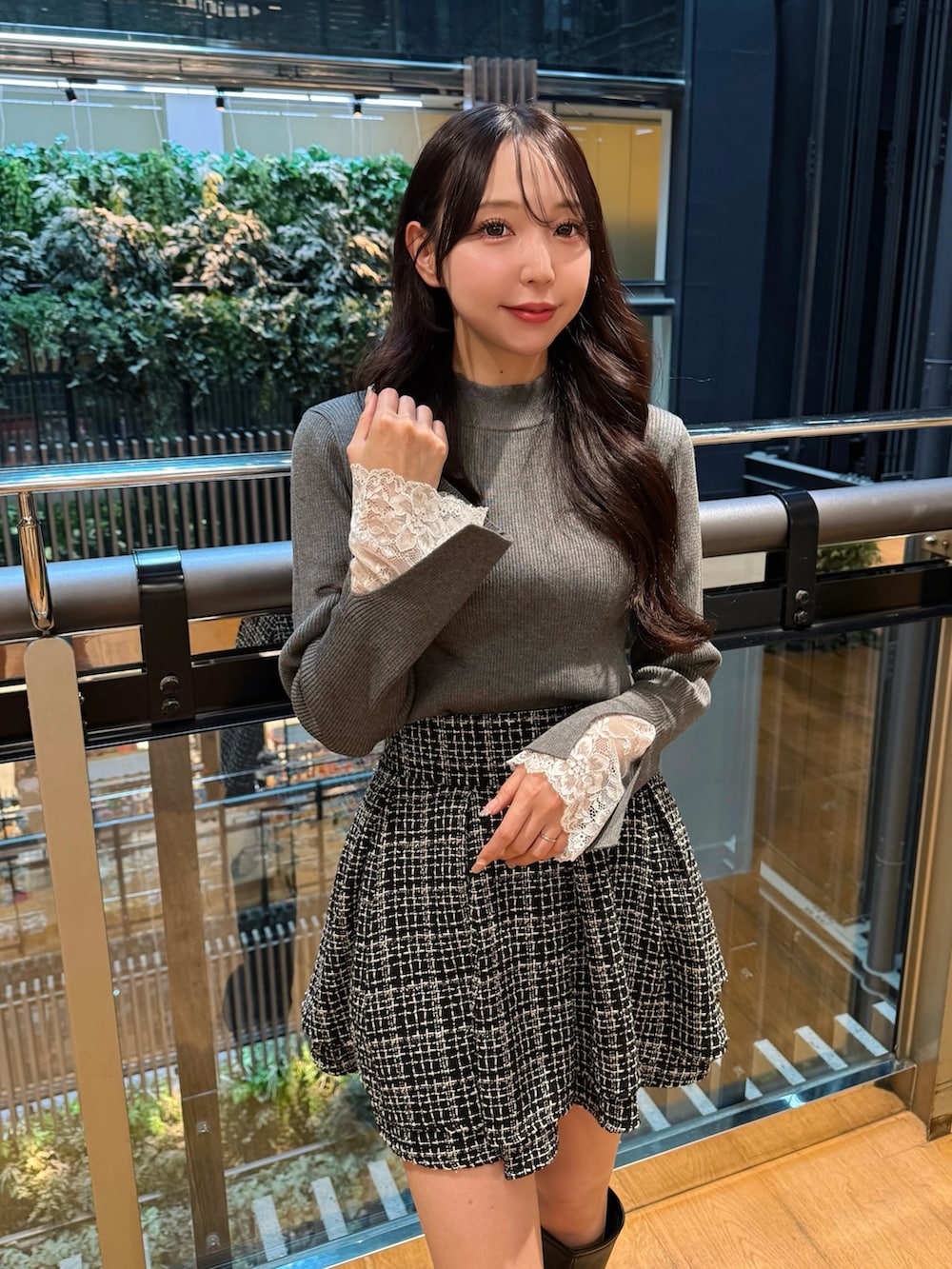 ホワイト系のトートバッグ、ブラック系のブーツ、ブラック系のスカートを着用したレディースの秋コーディネートの3枚目の写真