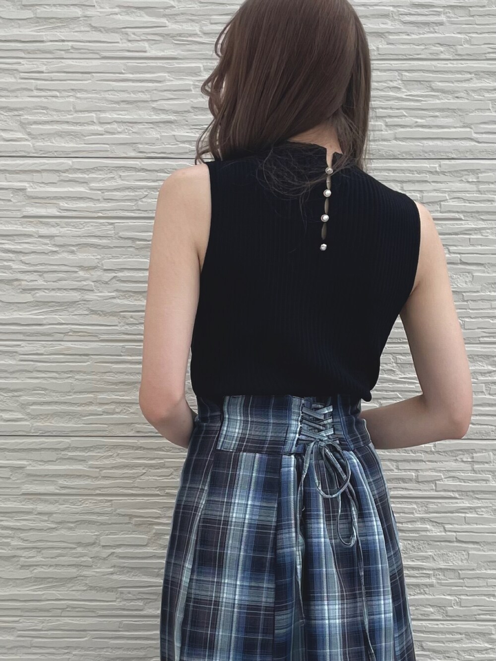 ホワイト系のサンダル、ブルー系のスカート、ブラック系のニット/セーターを着用したレディースの夏コーディネートの2枚目の写真