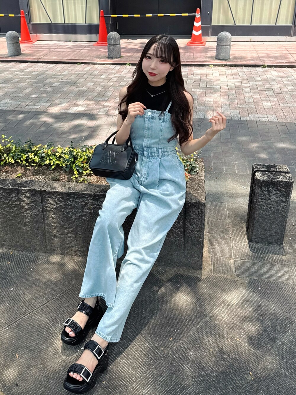 ブルー系のサロペット/オーバーオール、ブラック系のハンドバッグ、ブラック系のサンダルを着用したレディースの夏コーディネートの5枚目の写真