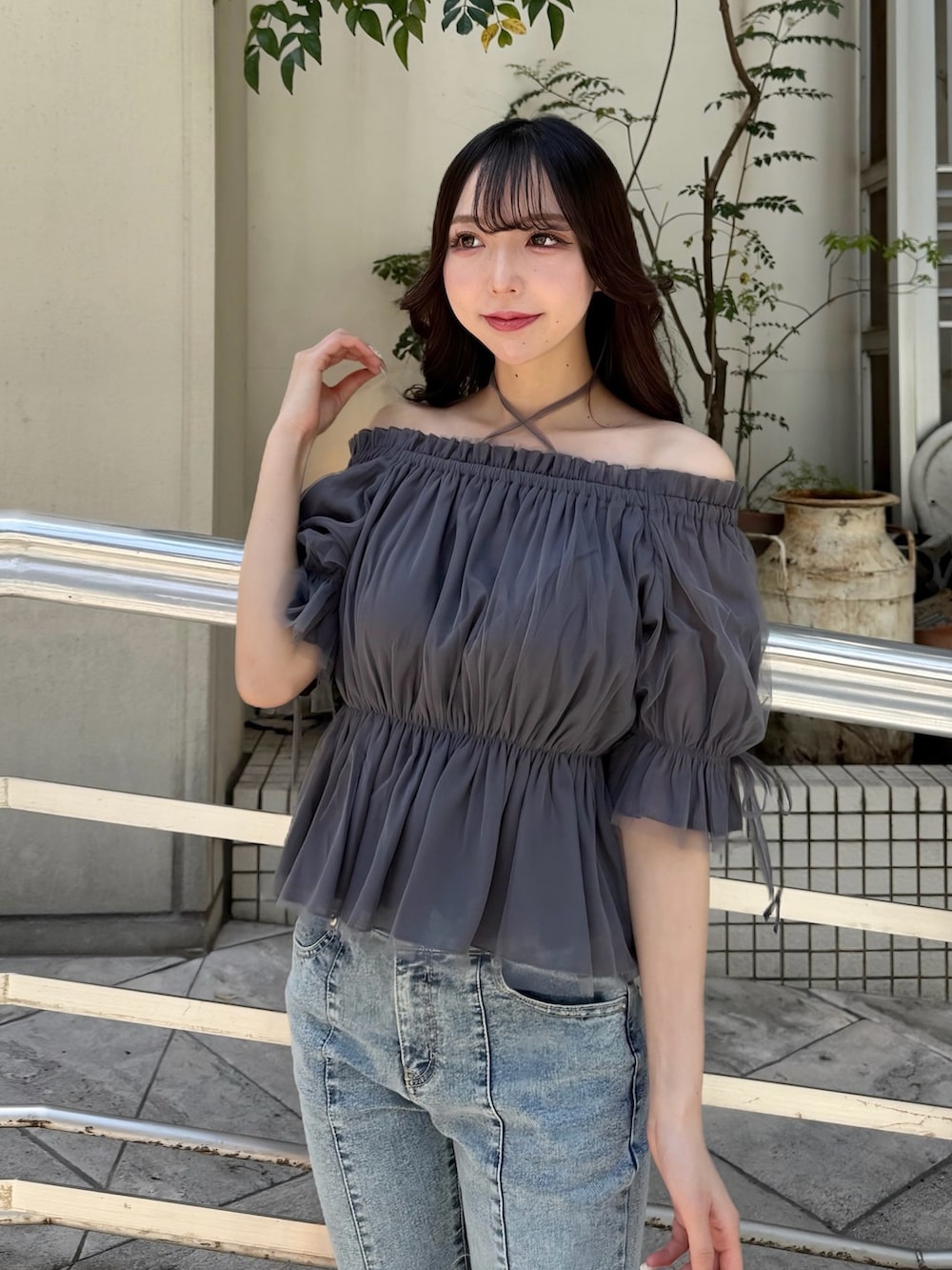 グレー系のシャツ/ブラウス、ブルー系のデニムパンツ、ブラック系のショルダーバッグを着用したレディースの春コーディネートの5枚目の写真