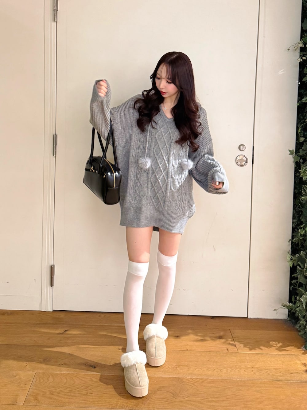 グレー系のパーカー、ベージュ系のブーツを着用したレディースの冬コーディネートの3枚目の写真