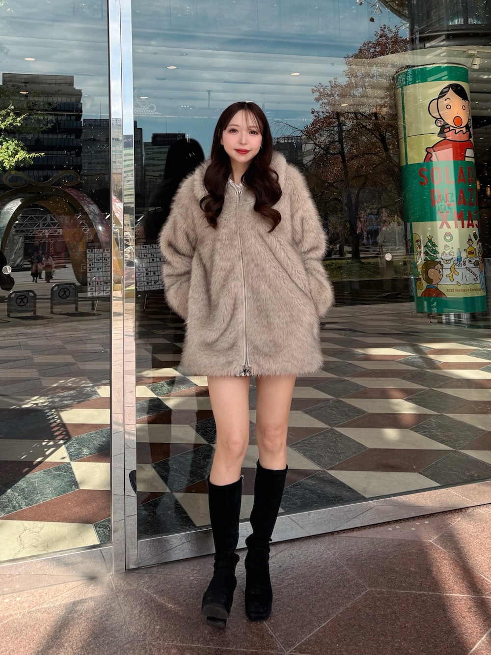 ベージュ系のブルゾンを着用したレディースの冬コーディネートの2枚目の写真