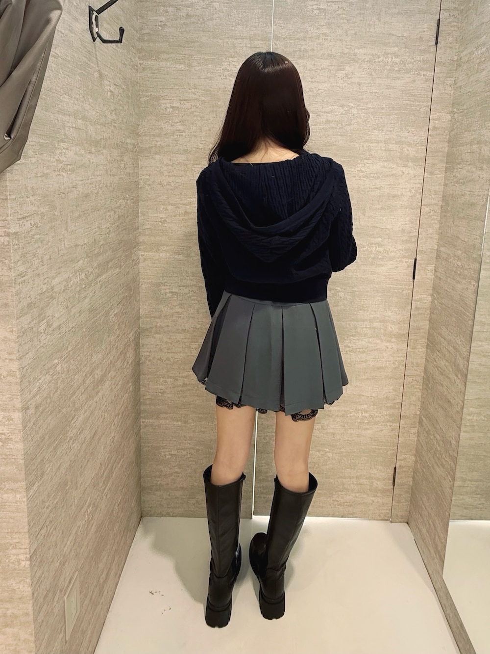 ブルー系のパーカー、グレー系のスカート、ブラック系のブーツを着用したレディースの冬コーディネートの3枚目の写真