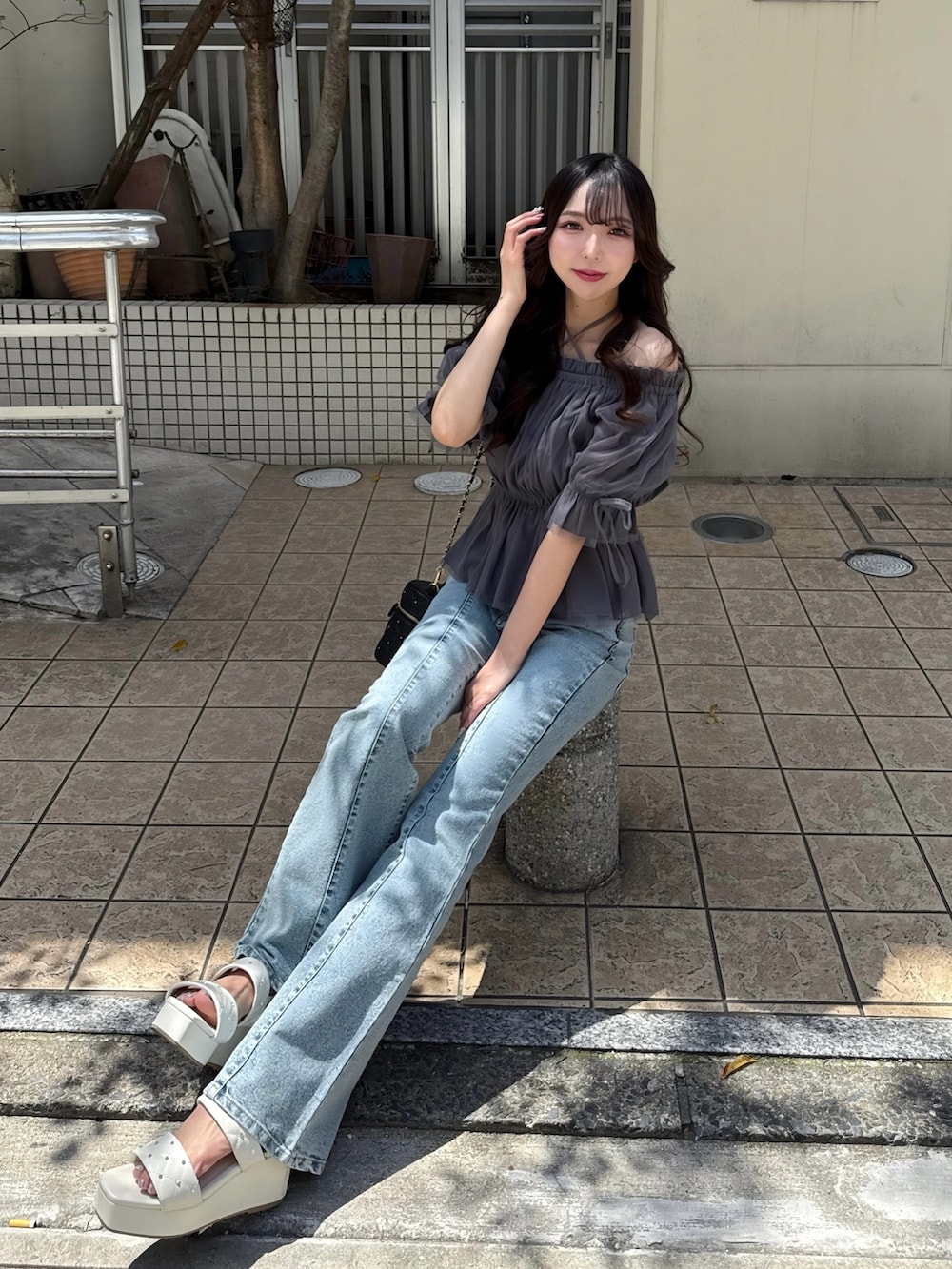 グレー系のシャツ/ブラウス、ブルー系のデニムパンツ、ブラック系のショルダーバッグを着用したレディースの春コーディネートの3枚目の写真