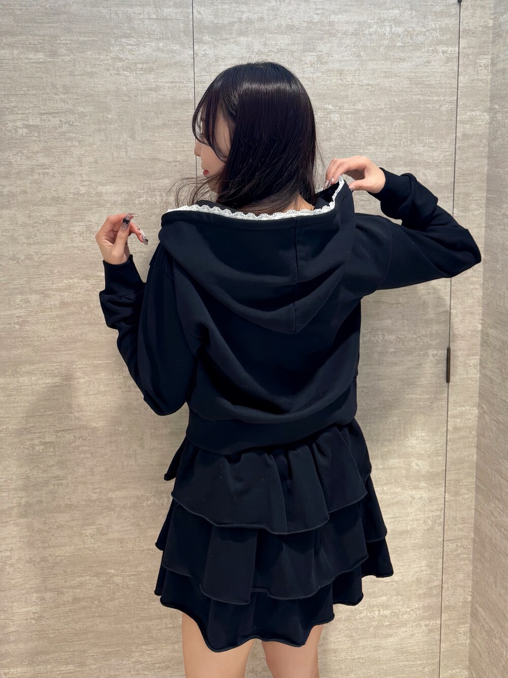 ブラック系のブーツ、ブラック系のスカート、ブラック系のパーカーを着用したレディースの秋コーディネートの4枚目の写真