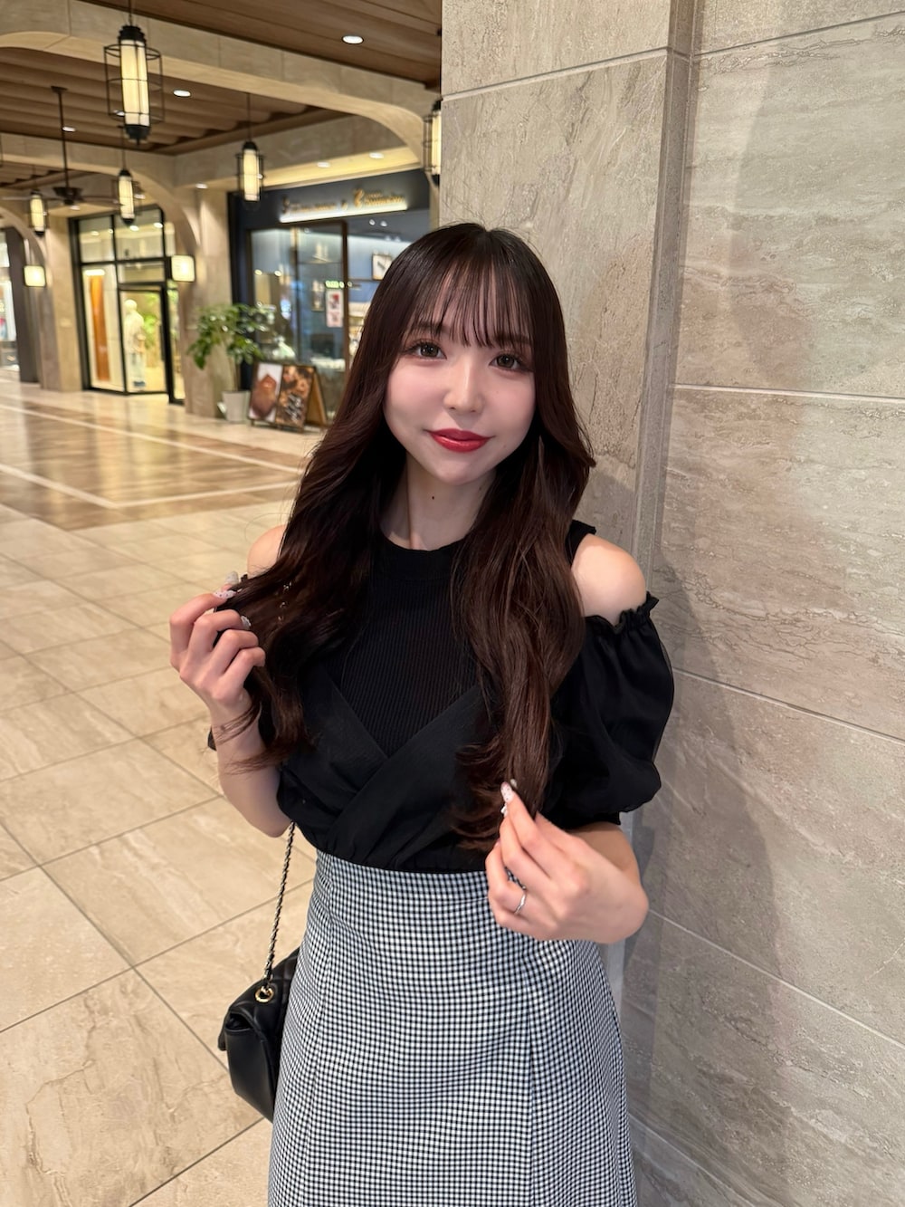 ブラック系のニット/セーター、ブラック系のスカート、ホワイト系のサンダルを着用したレディースの春コーディネートの3枚目の写真