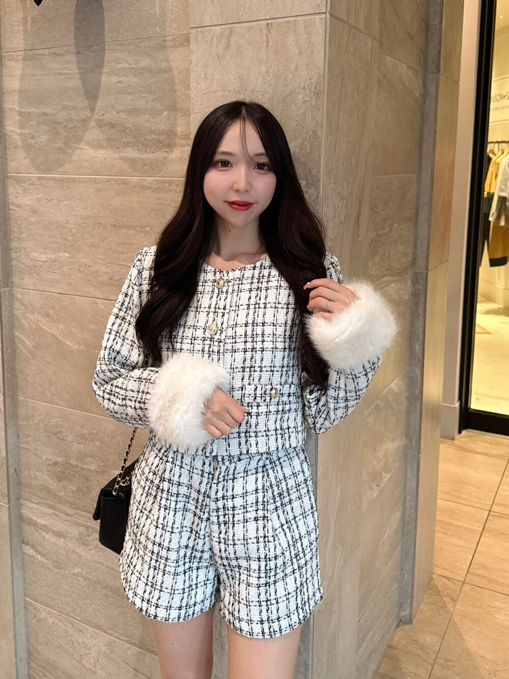 ホワイト系のノーカラージャケット、ホワイト系のその他パンツ、ブラック系のショルダーバッグを着用したレディースの秋コーディネートの7枚目の写真