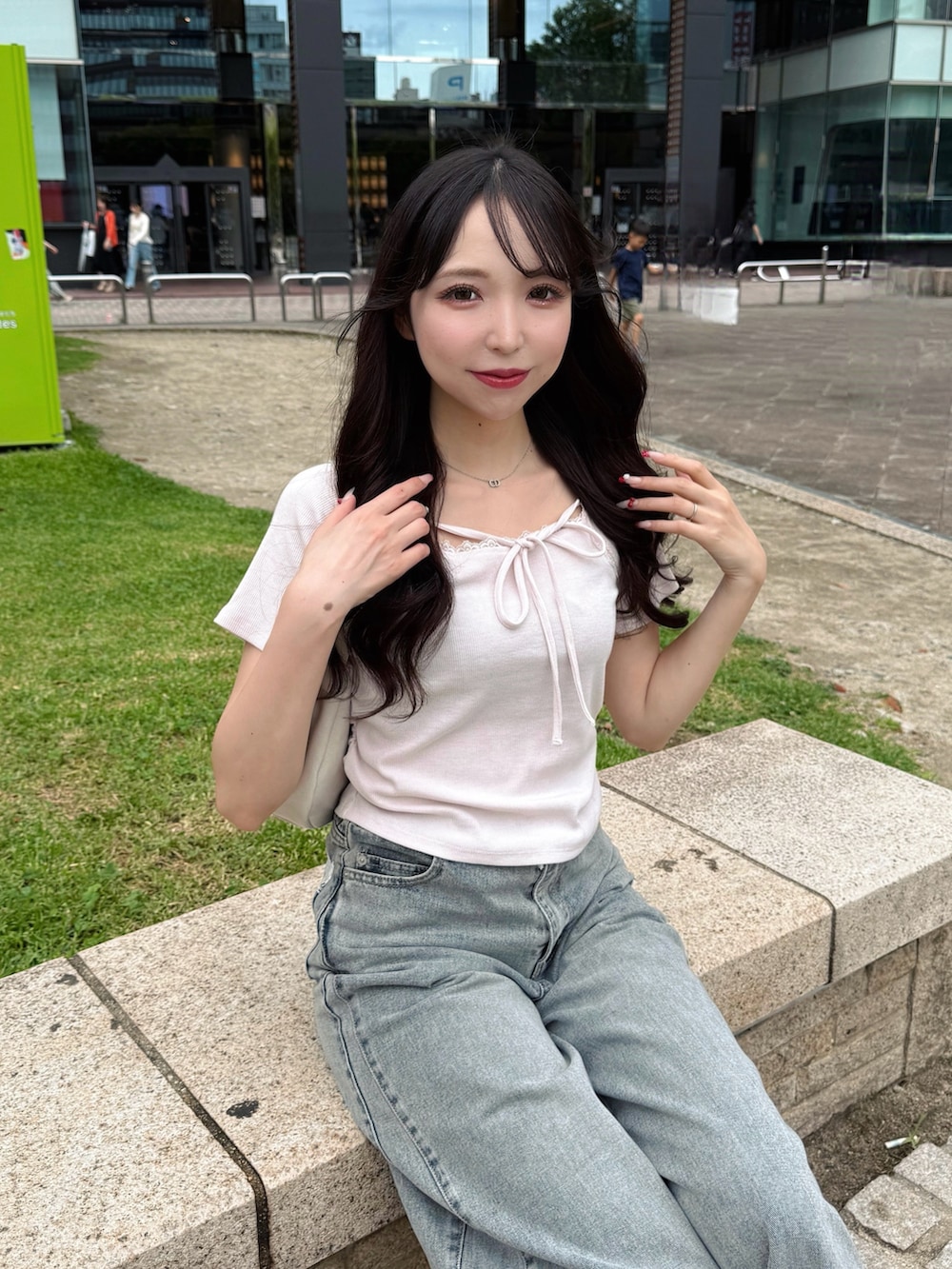 ブルー系のデニムパンツ、ピンク系のTシャツ/カットソー、ホワイト系のハンドバッグを着用したレディースの夏コーディネートの6枚目の写真