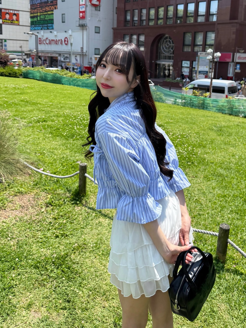 ブルー系のシャツ/ブラウス、ホワイト系のスカート、ホワイト系のサンダルを着用したレディースの夏コーディネートの2枚目の写真