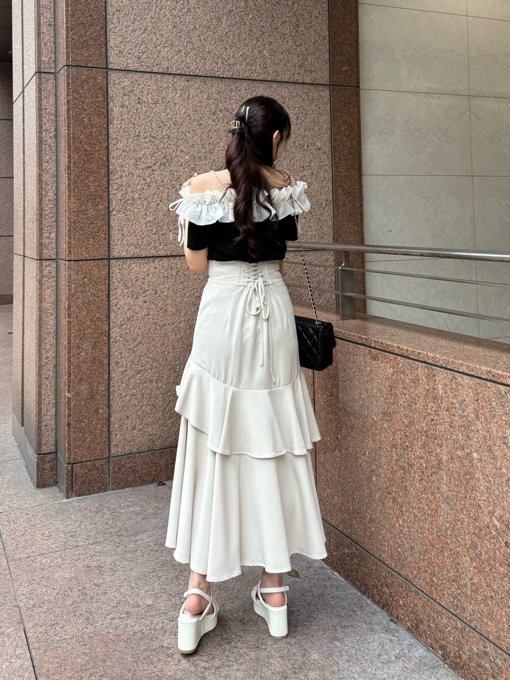 ブラック系のニット/セーター、ベージュ系のスカート、ブラック系のショルダーバッグを着用したレディースの夏コーディネートの6枚目の写真