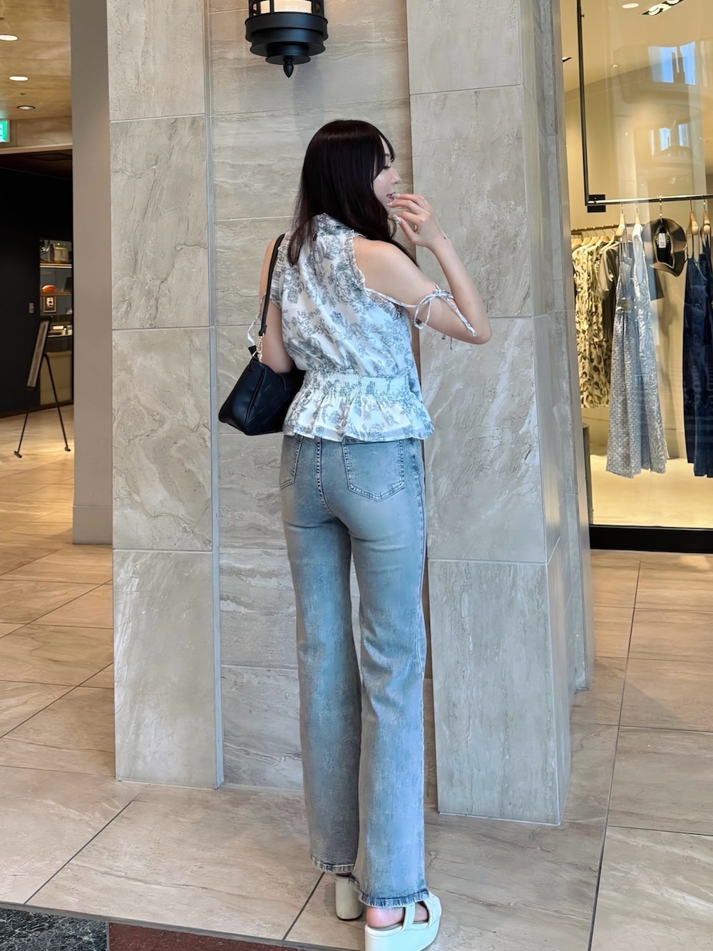 ブルー系のデニムパンツ、ホワイト系のシャツ/ブラウス、ホワイト系のサンダルを着用したレディースの夏コーディネートの4枚目の写真