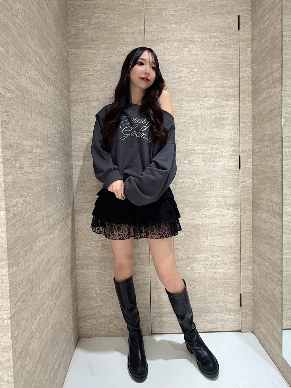 グレー系のスウェット、ブラック系のスカートを着用したレディースの秋コーディネートの3枚目の写真