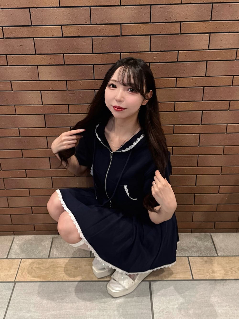 ブルー系のスカート、ブルー系のパーカー、ホワイト系のサンダルを着用したレディースの夏コーディネートの6枚目の写真