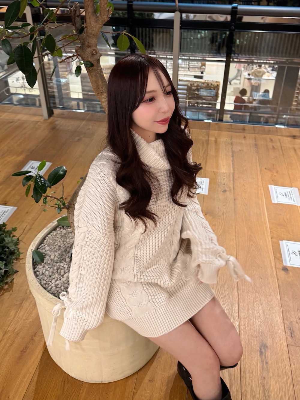 ホワイト系のチュニック、ブラック系のブーツを着用したレディースの冬コーディネートの4枚目の写真