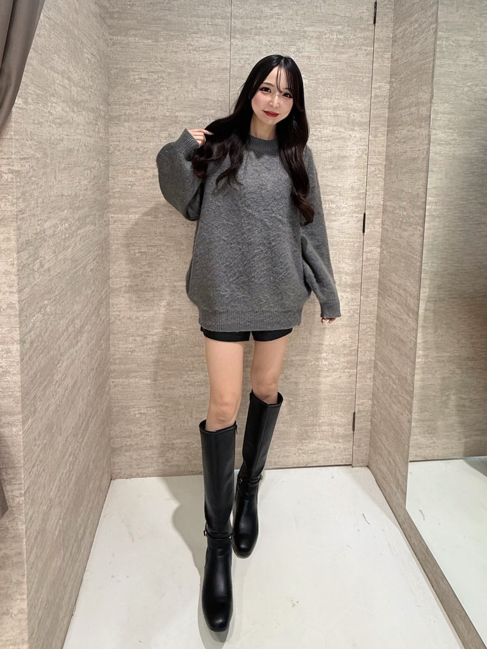 グレー系のニット/セーター、ブラック系のその他パンツ、ブラック系のブーツを着用したレディースの秋コーディネートの2枚目の写真