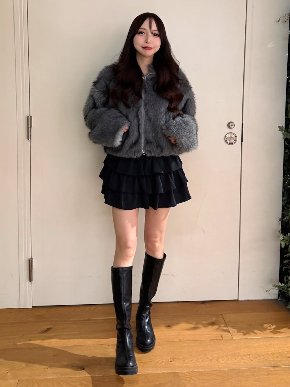 グレー系のブルゾン、ブラック系のスカートを着用したレディースの冬コーディネートの2枚目の写真