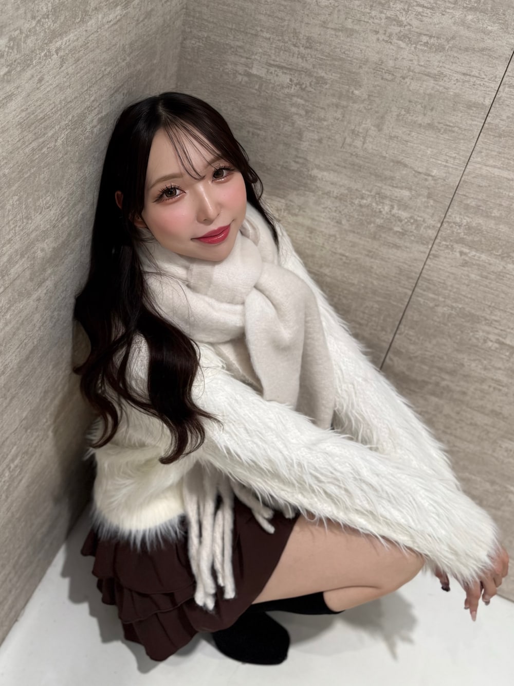 ホワイト系のニット/セーター、ブラウン系のスカート、ホワイト系のストール/ショールを着用したレディースの秋コーディネートの7枚目の写真