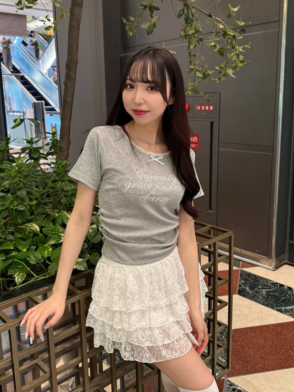 グレー系のTシャツ/カットソー、ホワイト系のスカート、ホワイト系のサンダルを着用したレディースの夏コーディネートの6枚目の写真
