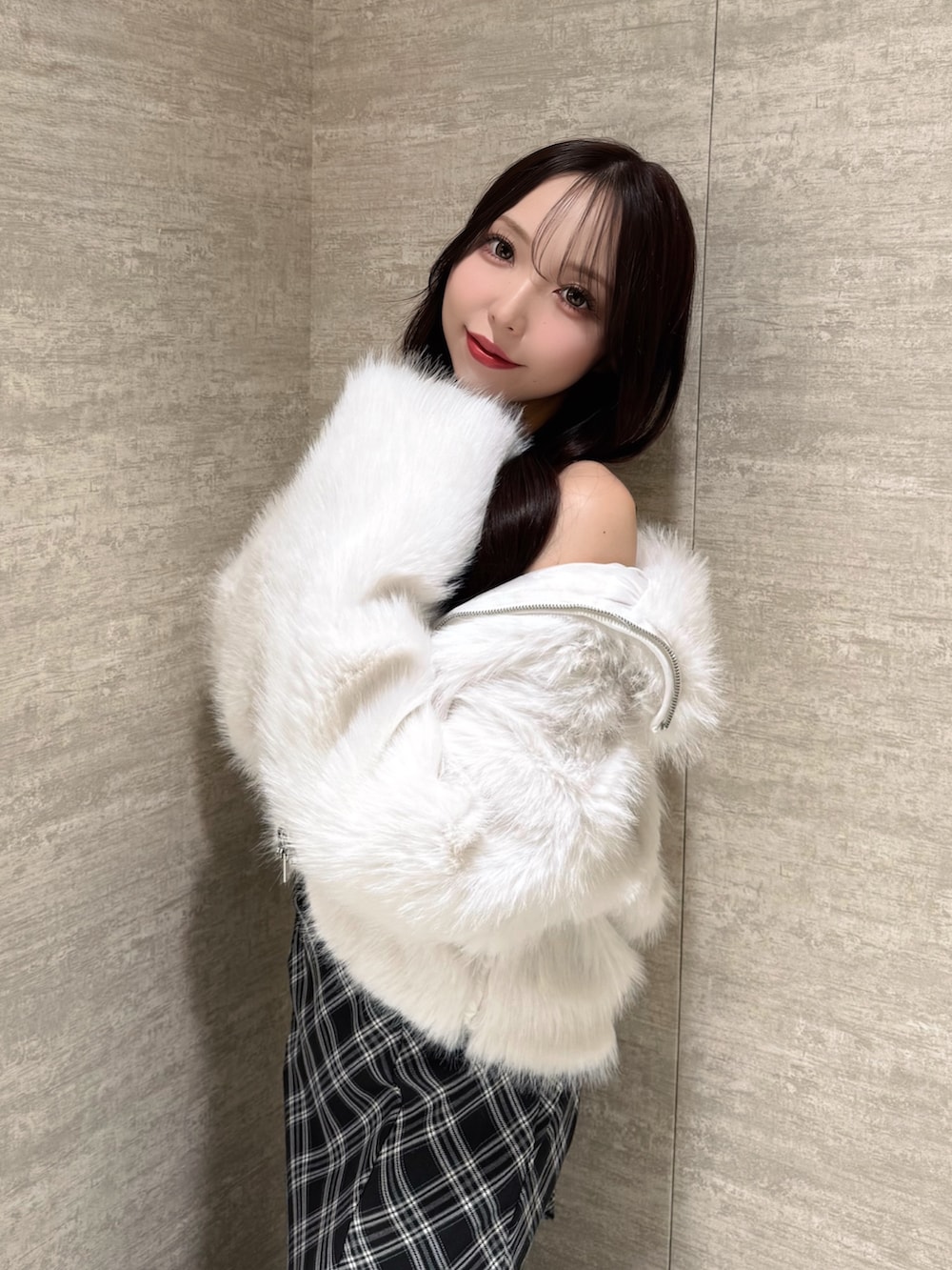 ホワイト系のブルゾン、ブラック系のワンピース、ブラック系のショルダーバッグを着用したレディースの秋コーディネートの6枚目の写真