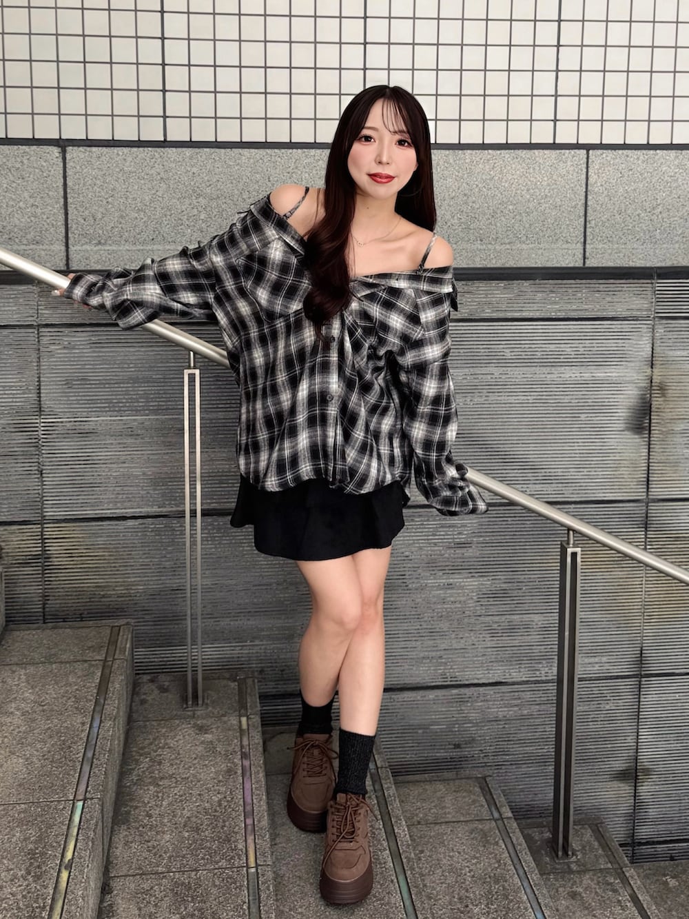 ブラック系のシャツ/ブラウス、ブラック系のスカート、ブラウン系のスニーカーを着用したレディースの秋コーディネートの2枚目の写真