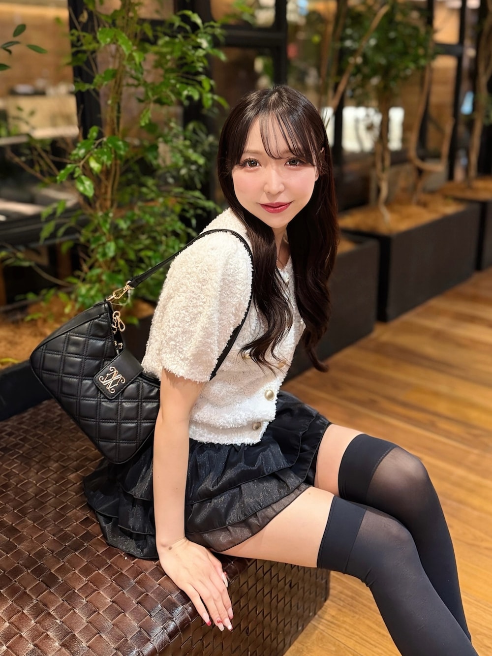 ホワイト系のカーディガン/ボレロ、ブラック系のスカート、ホワイト系のサンダルを着用したレディースの夏コーディネートの4枚目の写真