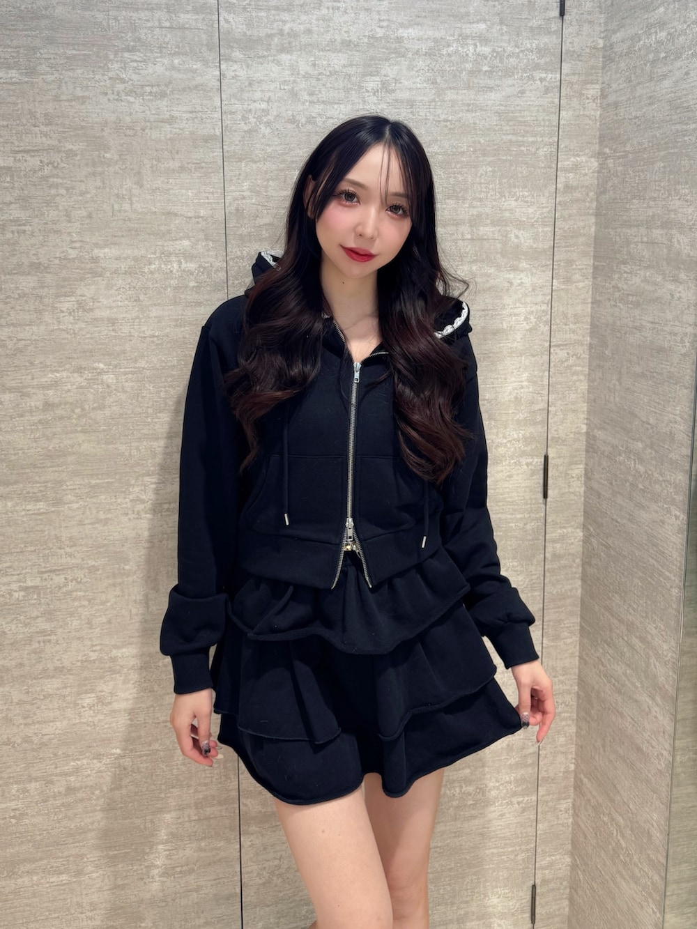 ブラック系のブーツ、ブラック系のスカート、ブラック系のパーカーを着用したレディースの秋コーディネートの5枚目の写真