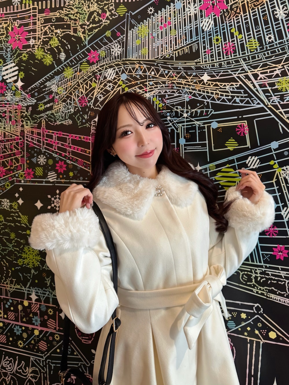 ブラック系のハンドバッグ、ホワイト系のその他アウターを着用したレディースの冬コーディネートの4枚目の写真