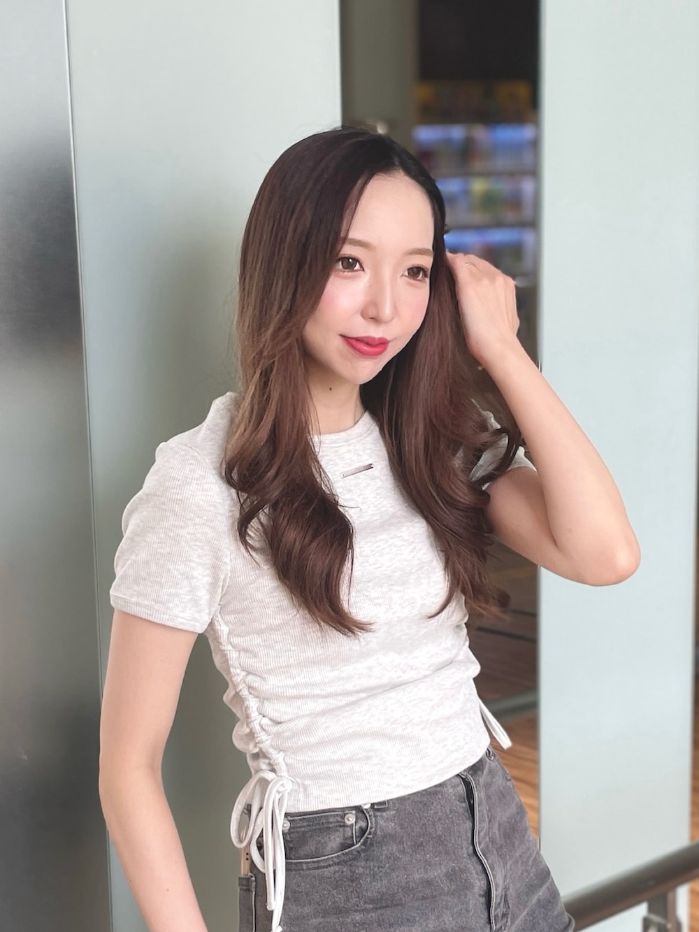 ベージュ系のTシャツ/カットソー、グレー系のデニムパンツ、ブラック系のショルダーバッグを着用したレディースの夏コーディネートの2枚目の写真