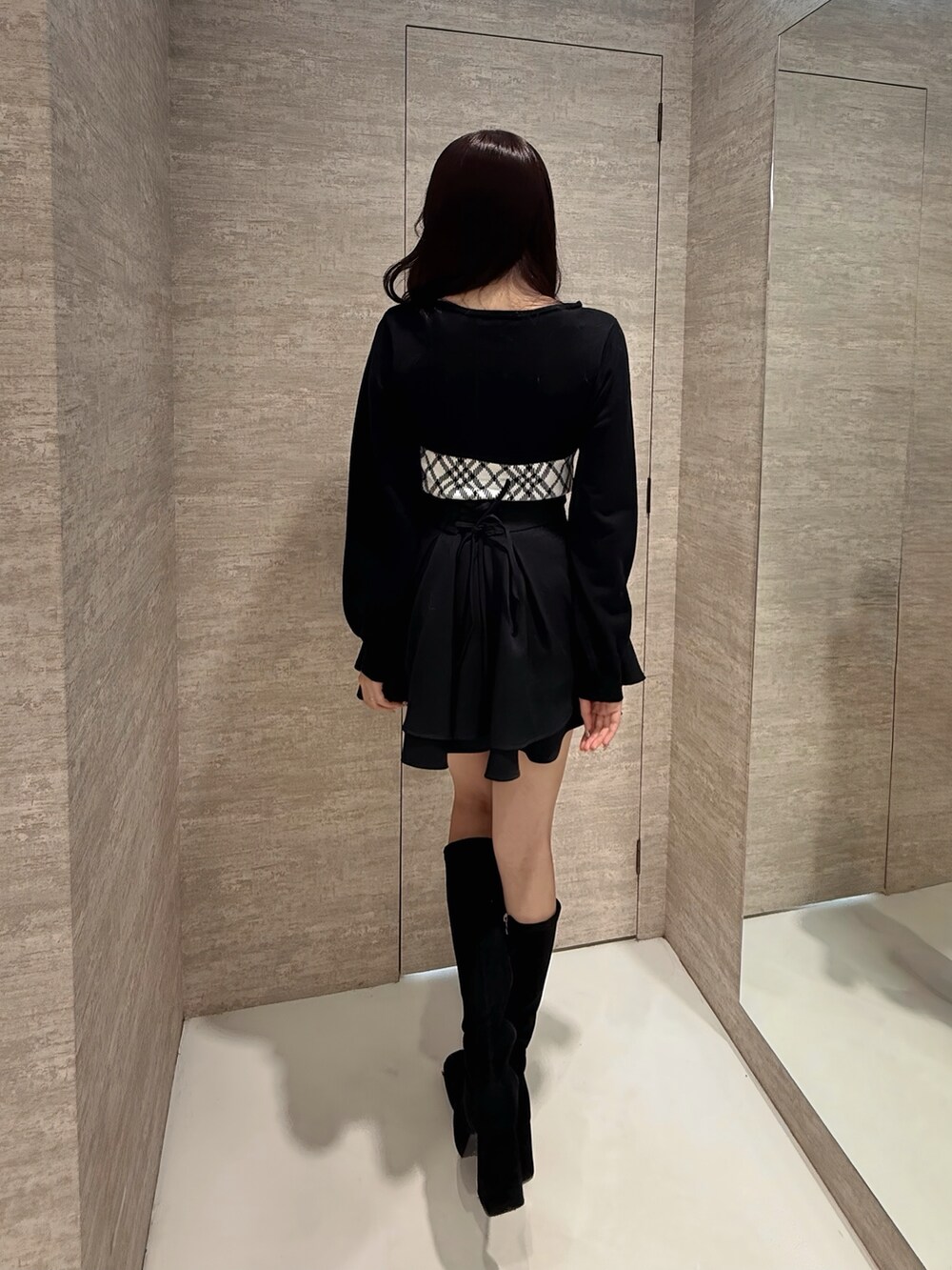 ホワイト系のニット/セーター、ブラック系のスカートを着用したレディースの冬コーディネートの4枚目の写真