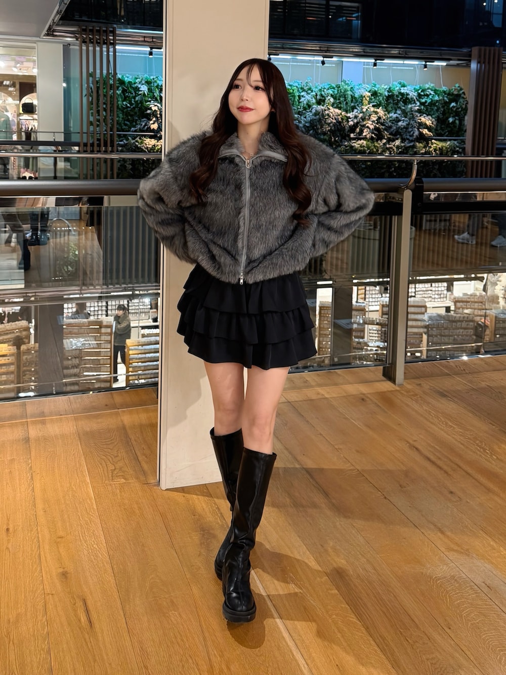 グレー系のブルゾン、ブラック系のスカートを着用したレディースの冬コーディネートの6枚目の写真