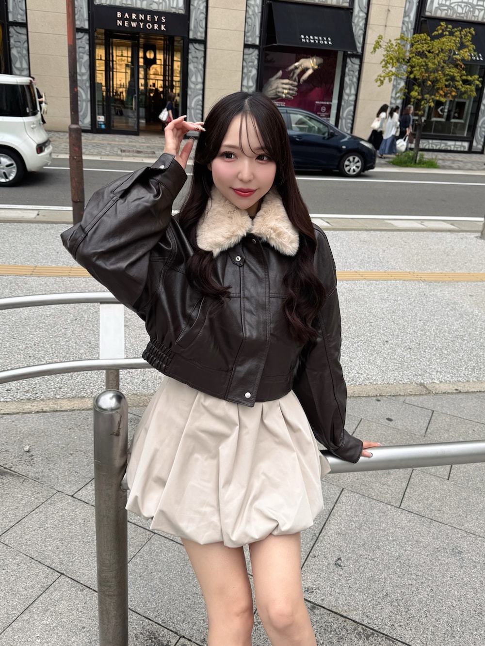 ブラック系のブルゾン、ベージュ系のスカート、ブラウン系のブーツを着用したレディースの秋コーディネートの5枚目の写真