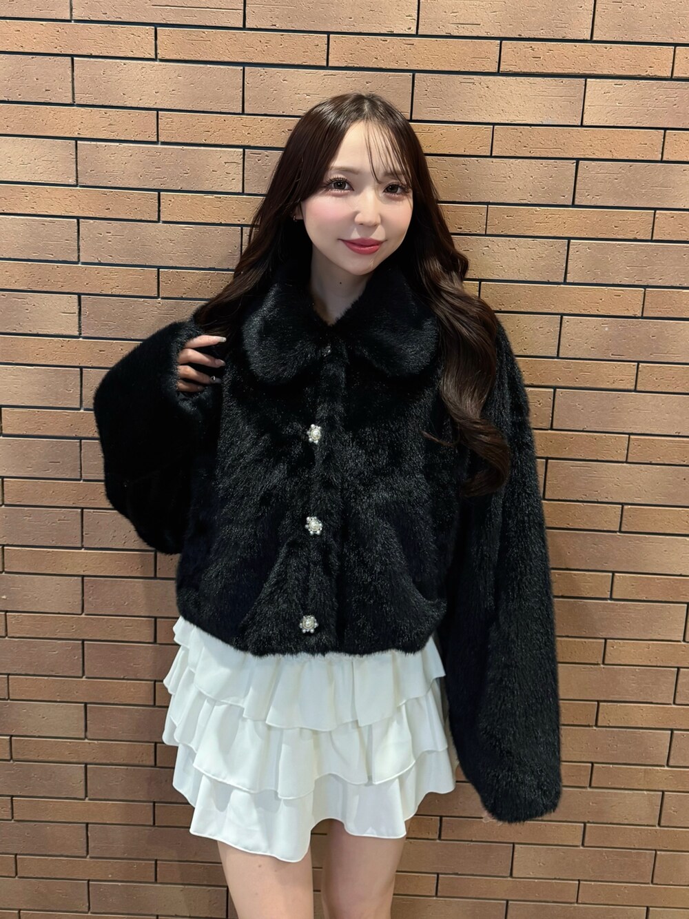 ブラック系のブルゾン、ホワイト系のスカートを着用したレディースの冬コーディネートの3枚目の写真