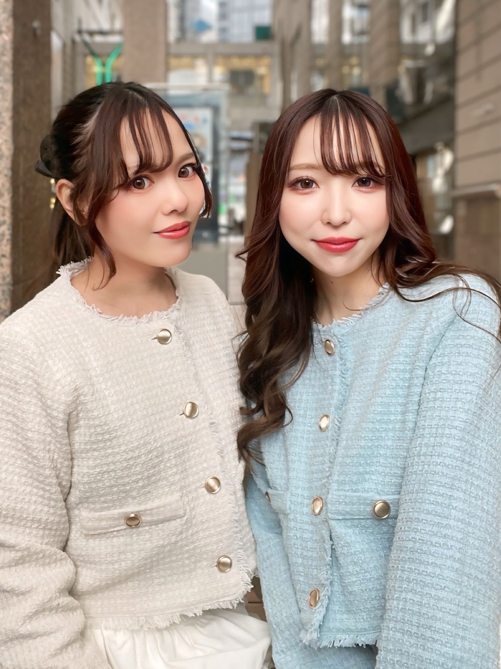 ブルー系のノーカラージャケット、ホワイト系のスカート、ブラック系のハンドバッグを着用したレディースの冬コーディネートの4枚目の写真