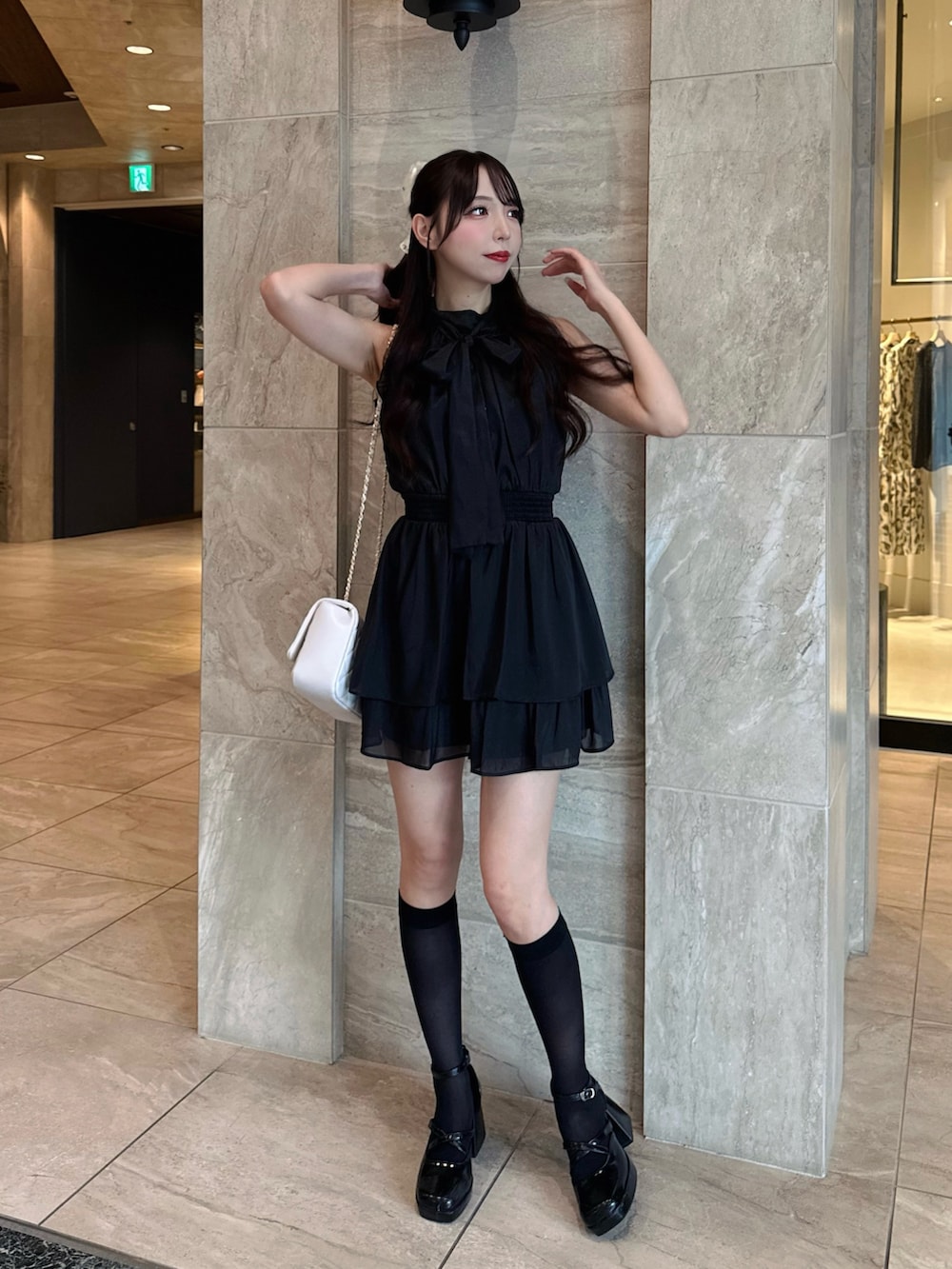 ブラック系のワンピース、ホワイト系のショルダーバッグを着用したレディースの夏コーディネートの4枚目の写真