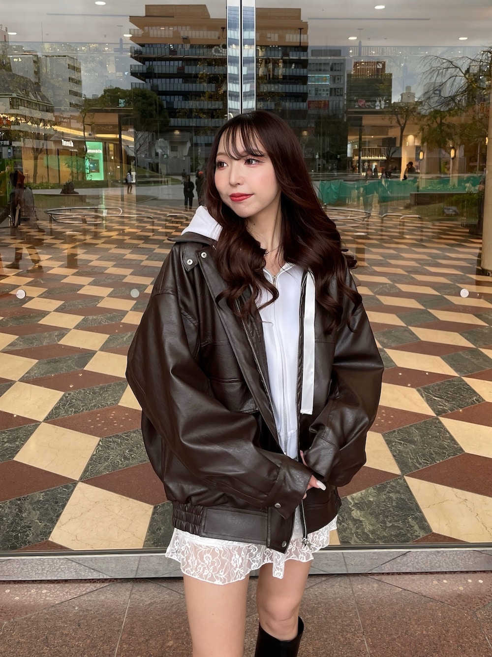 ホワイト系のスカート、ブラック系のブーツ、ホワイト系のパーカーを着用したレディースの春コーディネートの3枚目の写真