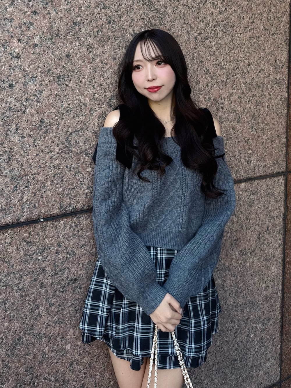 グレー系のニット/セーター、ホワイト系のショルダーバッグ、ブラック系のスカートを着用したレディースの秋コーディネートの7枚目の写真