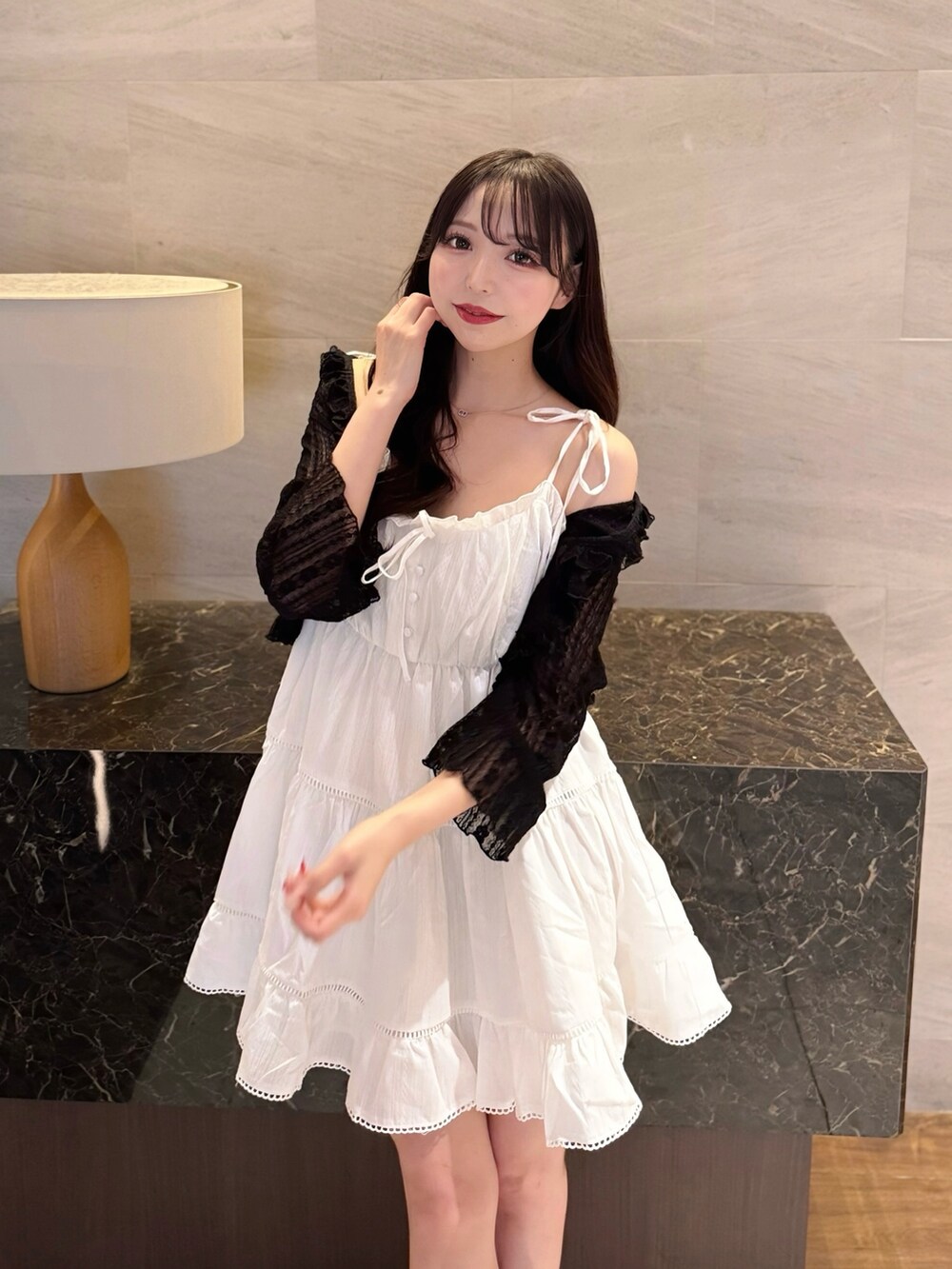 ホワイト系のワンピース、ブラック系のカーディガン/ボレロ、ホワイト系のサンダルを着用したレディースの夏コーディネートの6枚目の写真