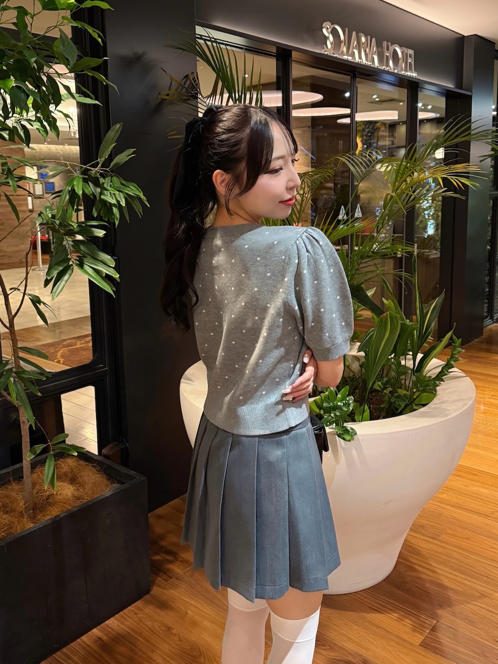 グレー系のカーディガン/ボレロ、グレー系のスカート、ブラック系のショルダーバッグを着用したレディースの秋コーディネートの2枚目の写真