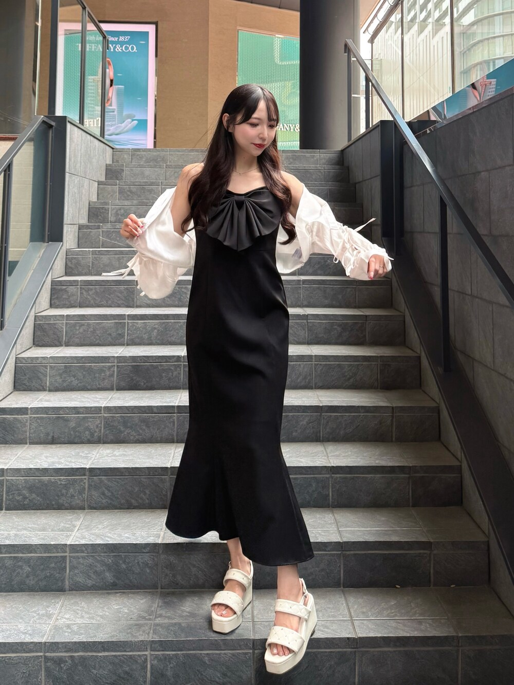 ブラック系のワンピース、ホワイト系のシャツ/ブラウス、ホワイト系のサンダルを着用したレディースの夏コーディネートの2枚目の写真