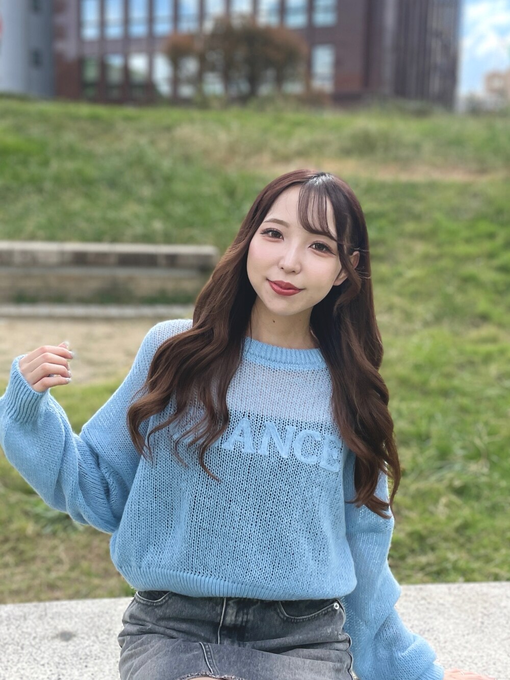 ブルー系のニット/セーター、グレー系のデニムスカートを着用したレディースの秋コーディネートの3枚目の写真
