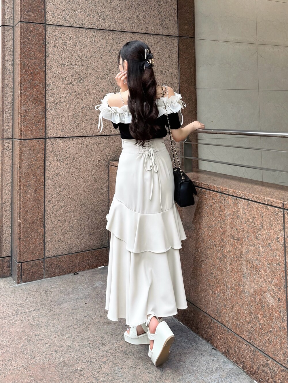 ブラック系のニット/セーター、ベージュ系のスカート、ブラック系のショルダーバッグを着用したレディースの夏コーディネートの5枚目の写真