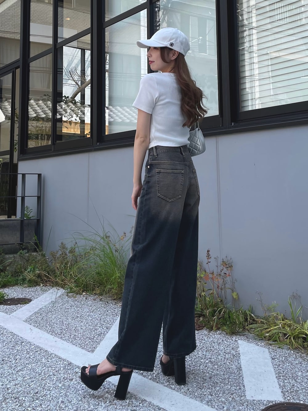 ブルー系のデニムパンツ、ホワイト系のTシャツ/カットソー、シルバー系のショルダーバッグを着用したレディースの夏コーディネートの2枚目の写真