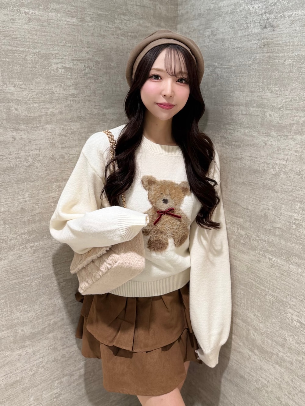 ホワイト系のニット/セーター、イエロー系のスカート、ベージュ系のショルダーバッグを着用したレディースの秋コーディネートの4枚目の写真