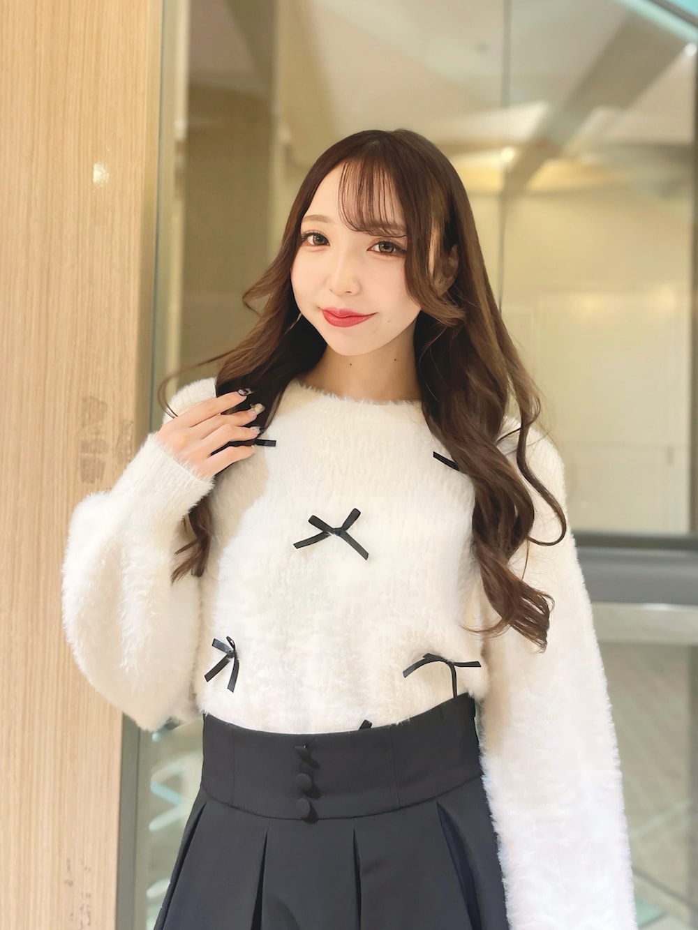 ブラック系のスカート、ホワイト系のニット/セーターを着用したレディースの秋コーディネートの2枚目の写真